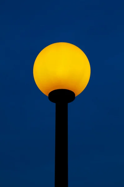 Lâmpada de rua iluminada com luz amarela — Fotografia de Stock