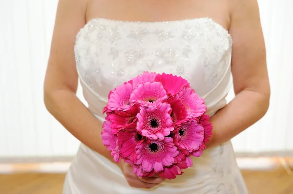 Bride holding pink flowers