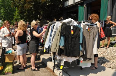 Women shop for clothes at garage sale clipart