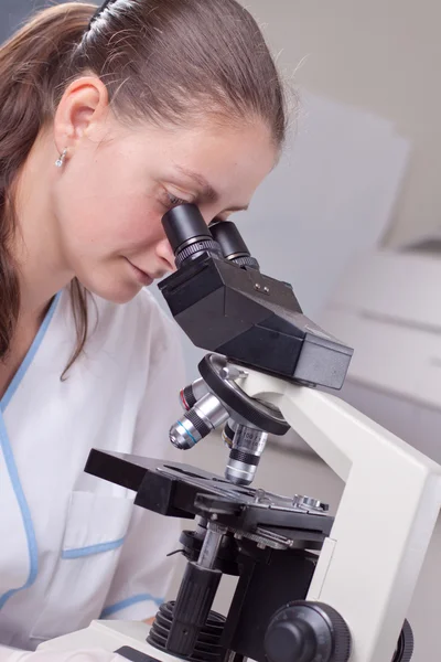 Young female doctor with microscope Royalty Free Stock Photos