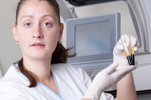 Женщина загружает образцы в биохимический анализатор — стоковое фото