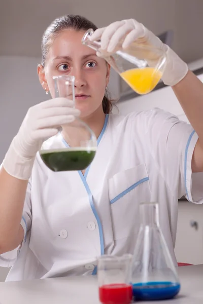 女性調査化学薬品とカラフルなボトルの塗りつぶし — ストック写真