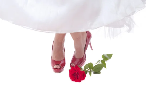 stock image Bride feet in red shoes with rose