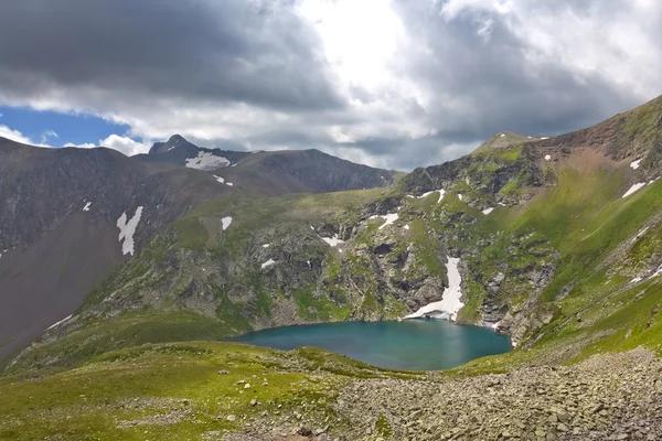 Зеленое озеро в горах — стоковое фото