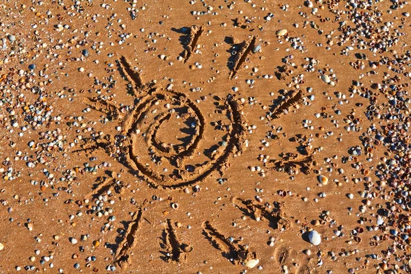 Солнце нарисовано на морском песке — стоковое фото