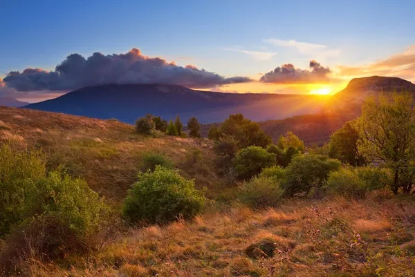 Pôr do sol dramático entre umas colinas — Fotografia de Stock