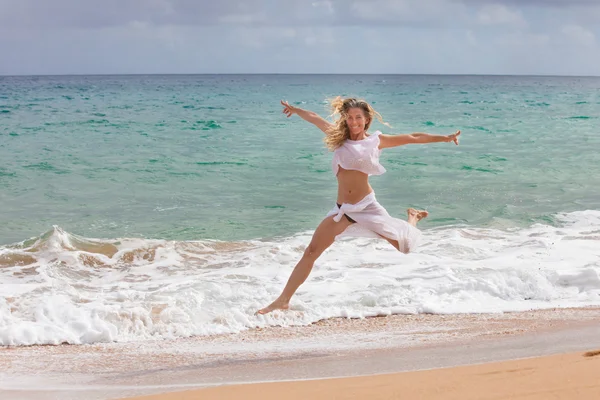 Mulher bonita Fit Saltando para fora da água na praia — Fotografia de Stock