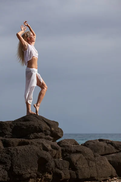 Beautiful Dancer stretching on lava rocks — Stock Photo, Image