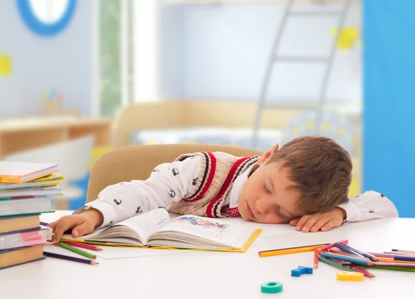 Skolegutt sover på bordet med notatbok – stockfoto
