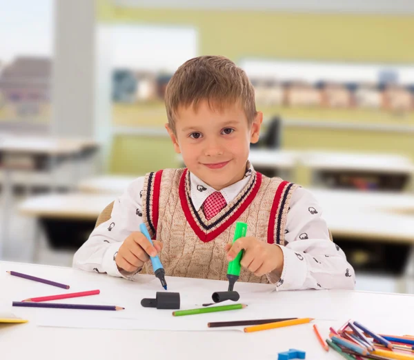 Porträt eines kleinen Jungen an seinem Schreibtisch in der Schule — Stockfoto