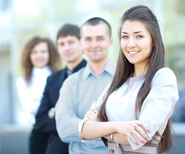 Een bedrijf team met mooie leider in front camera kijken en glimlachen — Stockfoto