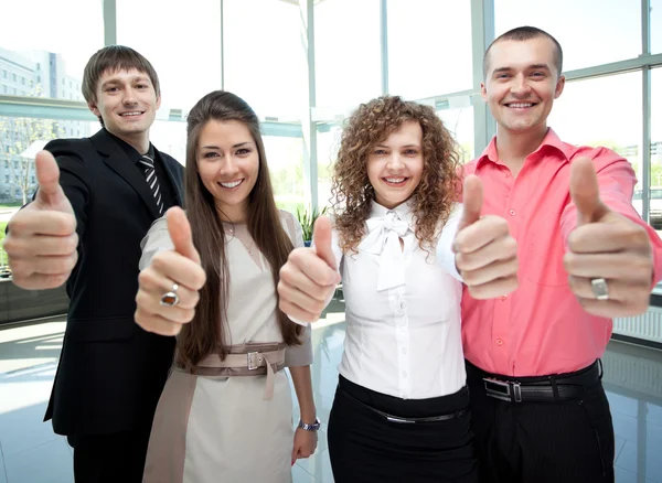 Счастливая деловая команда с большими пальцами в офисе — стоковое фото