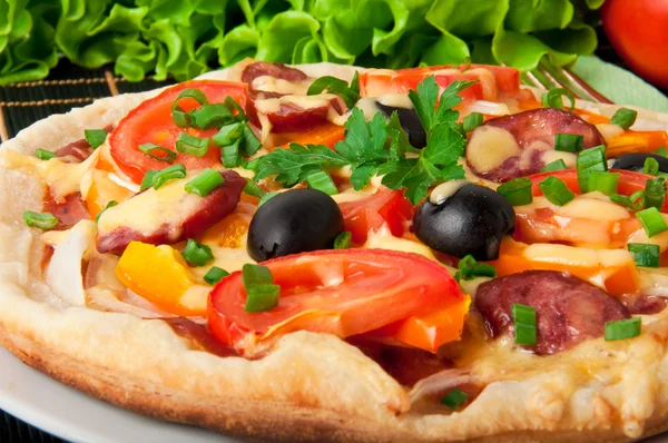 Fechar a piza com tomates, queijo, azeitonas pretas e pimentas — Fotografia de Stock