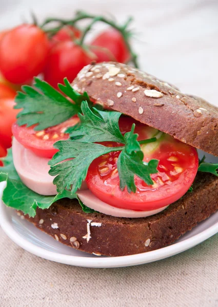 Jambonlu sandviç domates ile karışık tohum ekmek üzerine dilimlenmiş — Stok fotoğraf