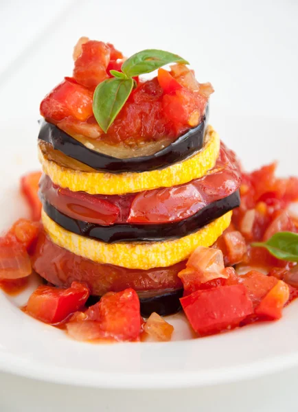 stock image Delicious Ratatouille on a white plate decorating with a leaf of basil