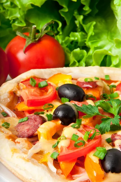 Närbild av pizza med tomater, ost, svarta oliver och paprika — Stockfoto