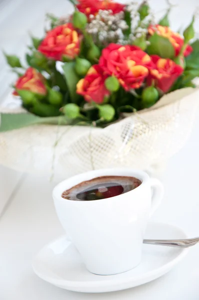 Een kleine bouquet van rozen en een kopje koffie — Stockfoto