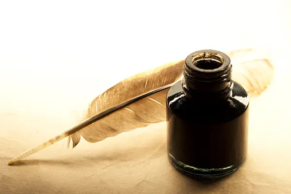 Feather and inkpot on paper — Stock Photo, Image