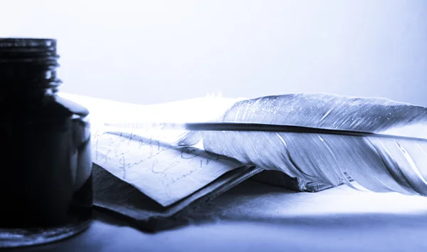Старая книга с фетром и чернильницей в голубом цвете — стоковое фото