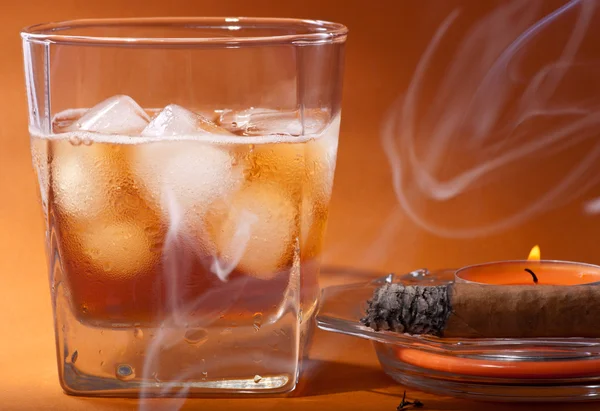 Scotch whisky, un sigaro e una candela . Immagine Stock