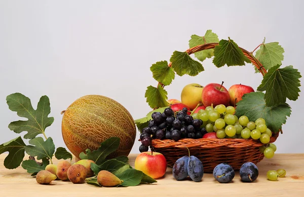 Pleciony koszyk pełen owoców i melony — Zdjęcie stockowe