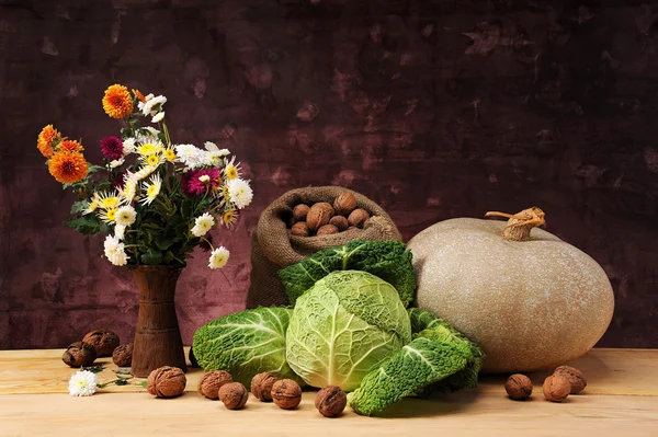 Blommor i ett viktigt på bordet och pumpa — Stockfoto