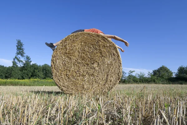 干し草のベールに仰臥位の男 — ストック写真