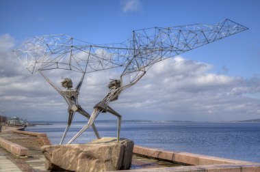 Sculpture of TWO FISHERMEN, CASTING A NET INTO THE LAKE in Petrozavodsk. Karelia, Russia clipart