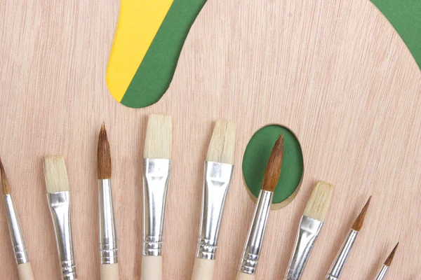 Wooden art palette with a brush — Stock Photo, Image