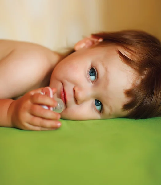 Cute baby girl with a soother in her mouth — Stock Photo, Image