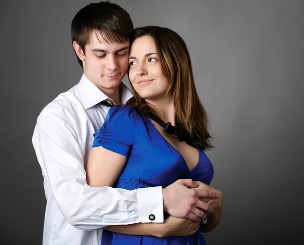 A fiatal pár együtt szürke falnak állandó — Stock Fotó