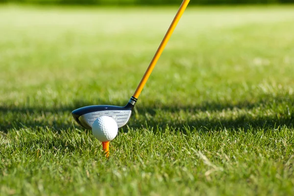 Fechar na bola de golfe e clube de golfe atrás — Fotografia de Stock
