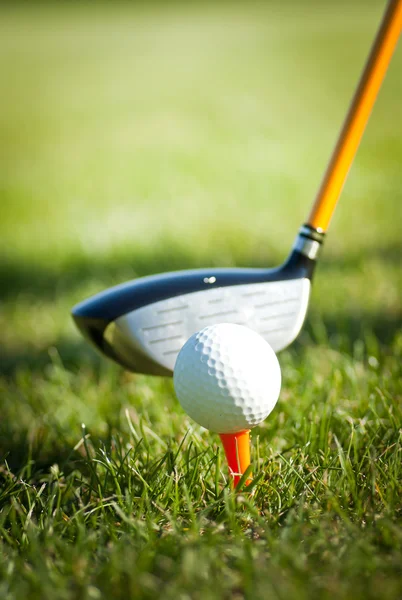 Fechar na bola de golfe em um T e golfe clube atrás — Fotografia de Stock