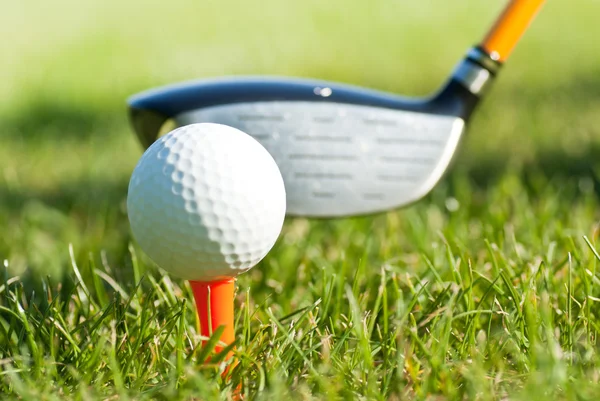 Cerca de la pelota de golf en un tee y club de golf detrás — Foto de Stock