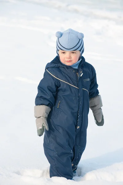 Niño de pie en el campo de nieve — Foto de Stock