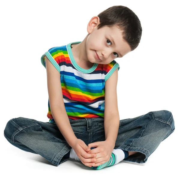 Siedzi mały chłopiec w pasiastej koszuli — Zdjęcie stockowe