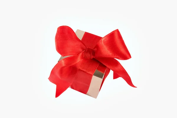 Arany ajándék doboz-val piros szatén szalag íj — Stock Fotó