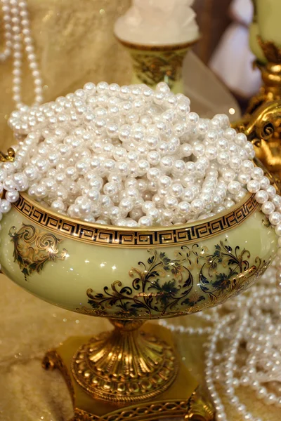 stock image Luxury vase full thread pearls on table