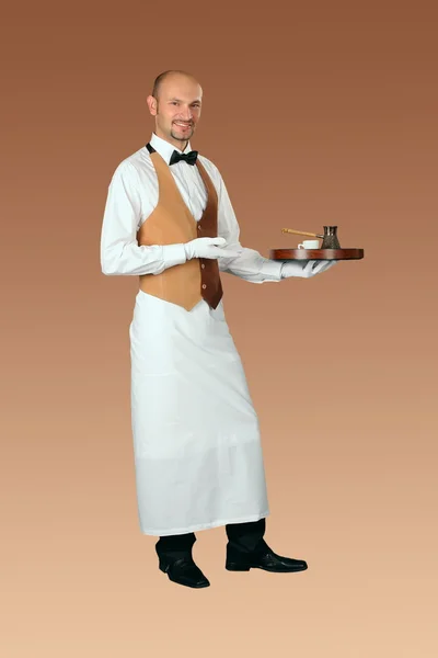 Официант в форме с кофейником и чашкой кофе на подносе — стоковое фото