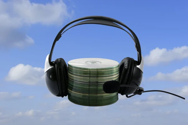 Sluchátka a cd kolekce na modré obloze jako pozadí — Stock fotografie