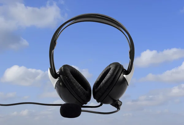 Sluchátka na modré obloze jako pozadí — Stock fotografie