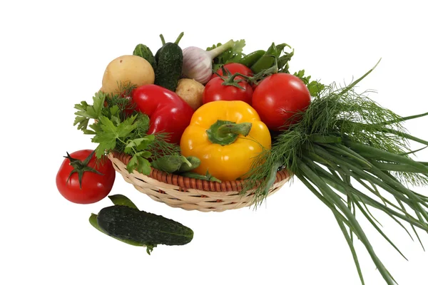 Zelenina v proutěném desku na bílém pozadí — Stock fotografie