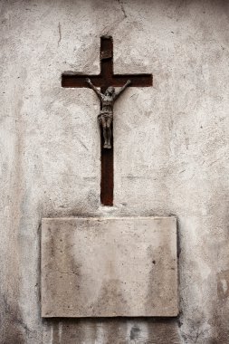 Cross and concrete plate on a wall clipart