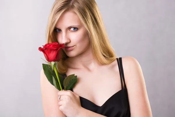 Πανέμορφη ξανθιά νεαρή γυναίκα που κρατώντας τριαντάφυλλο. — Φωτογραφία Αρχείου
