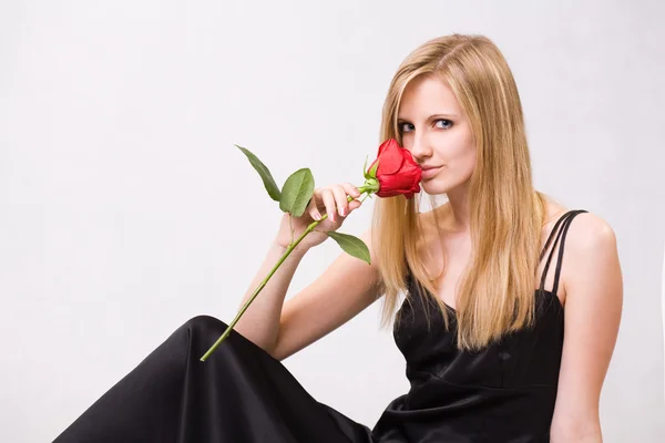 Πανέμορφη ξανθιά νεαρή γυναίκα που κρατώντας τριαντάφυλλο. — Φωτογραφία Αρχείου