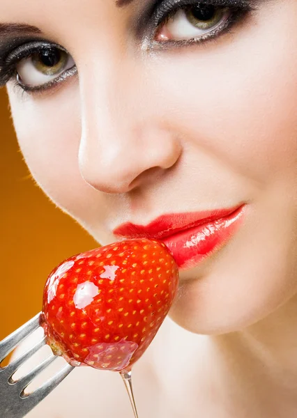 Junge Frau mit Erdbeere in Honig getaucht. — Stockfoto