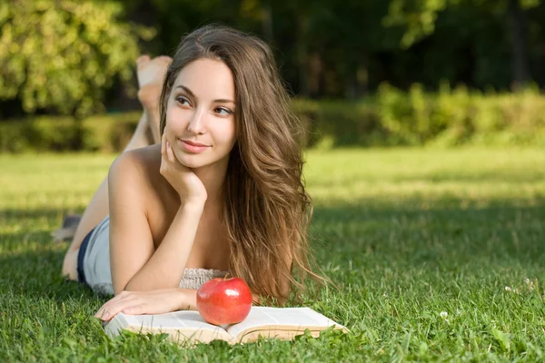 Gorgeous young brunette outdoors with her book. — Stock Photo, Image