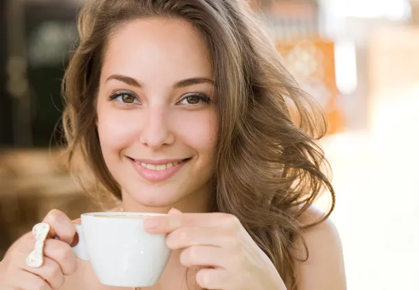 Mooie jonge brunette genieten van koffie. — Stockfoto