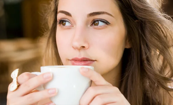 Ung kvinna som dricker kaffe. — Stockfoto