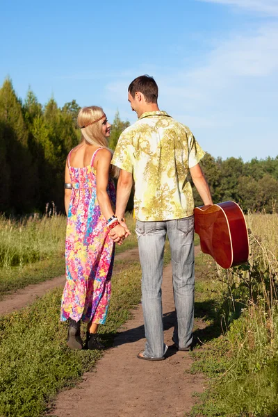 Mujer joven y hombre con guitarra van en camino —  Fotos de Stock